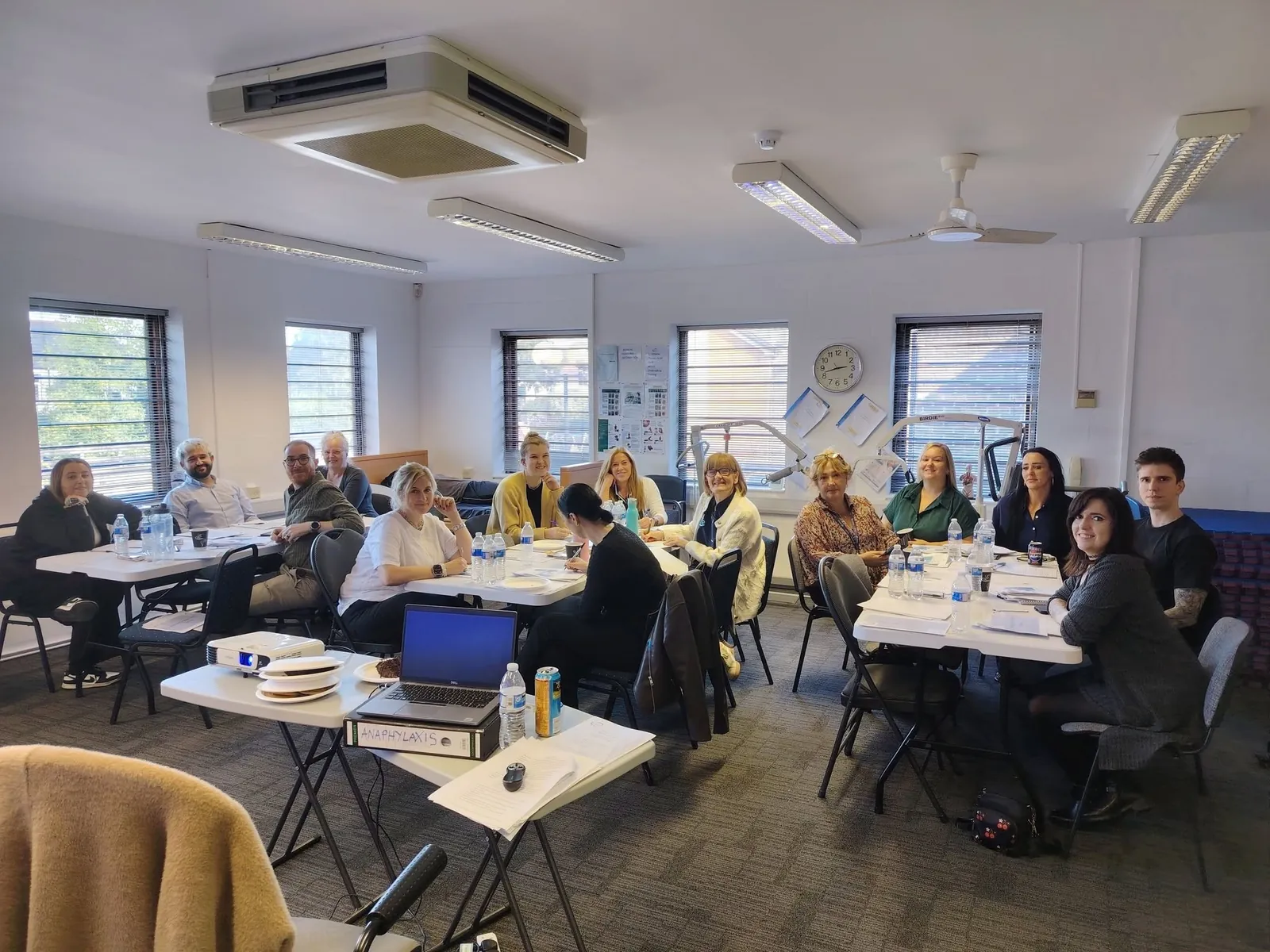 Learners around tables in the Healthcare Academi Cymru training room in Canton, Cardiff
